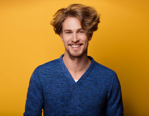 Wall Mural - Portrait of Young Handsome Man Happily Smiling Against Yellow Studio Background	