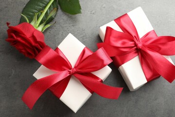 Sticker - Gift boxes with bows and rose on grey table, flat lay