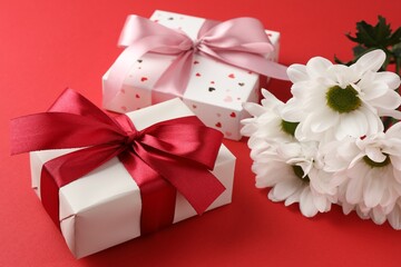 Poster - Gift boxes with bows and flowers on red background