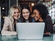 © zumrud - Group of joyful young women looking at laptop screen together
