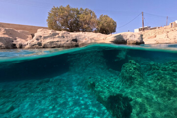 Underwater split photo of paradise exotic island rocky bay with crystal clear turquoise sea in Caribbean destination island