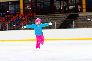 Child skating on indoor ice rink. Kids skate.