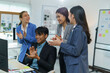 ©  NCST Studio - Happy and diverse business team is clapping in a modern office, celebrating their success and achievements