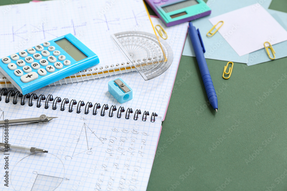 Notebooks with calculator and school stationery on chalkboard
