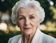 © Julija - Sophisticated older French woman is in the open air. Demeanor reveals a lifetime of experiences and reflections, embodying grace and wisdom. Well-groomed woman 70 years old with grey hair. AI