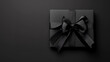 © ChristacilinCreative - A gift wrapped in black paper and satin bow on solid matching background Christmas anniversary wedding engagement gift present