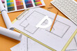 © Pixel-Shot - Architect's supplies with house plan on orange background, closeup