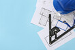 © Pixel-Shot - Architect's supplies with house plans on blue background