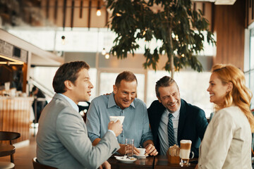 Group of business people having coffee and talking in a cafe decorated for the christmas and new year holidays