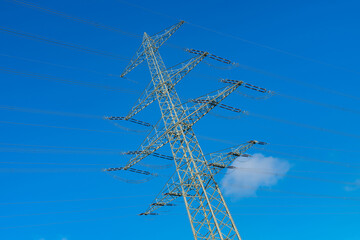 Tall power transmission tower against clear blue sky