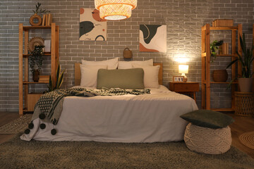 Canvas Print - Interior of bedroom with bed, shelving units, bedside table and glowing lamp