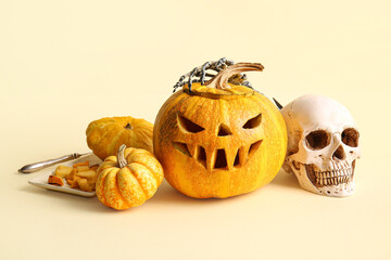 Sticker - Halloween carved pumpkins with human skull and skeleton hand on beige background