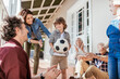 © Marko Geber - Multigenerational family playing with soccer ball on house porch