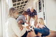 © Marko Geber - Grandparents and grandchildren playing with soccer ball on house porch