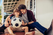 © Marko Geber - Father and son bonding while playing with a soccer ball on house porch