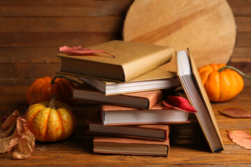 Wall Mural - Composition with stack of books, pumpkins and autumn leaves on wooden background