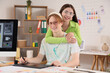 © Pixel-Shot - Young couple of graphic designers hugging in office
