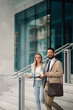 © Zamrznuti tonovi - Business people leaving office building holding coffee and tablet having informal meeting
