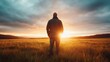© Dulemegapixel - A solitary figure stands with hands in pockets, silhouetted against the stunning sunrise, reflecting a moment of introspection and peace in the vast open field.