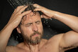 © Volodymyr - Man washing hair in bath. Guy bathing shower head in bathtub. Face in foam in shower. Bathing man taking shower. Close up guy showering. Shower concept. Man is under water drops in showers.