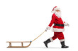 © Ljupco Smokovski - Santa Claus walking with a wooden sled and looking at camera