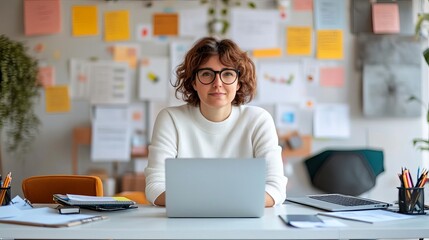 Startup founder at a co-working space, surrounded by laptops and business materials