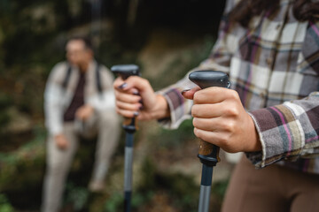 Wall Mural - close up of unknown adult woman hold hiking sticks, trekking poles