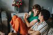 © qunica.com - A young couple sitting on a couch sharing a playful and joyful moment. They appear relaxed and happy, surrounded by cozy home decor.