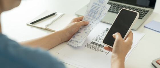 woman use phone scan barcode or qr codes to pay credit card bill after receiving document invoice. p