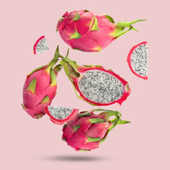 Poster - Yummy pitaya fruits falling on pink background