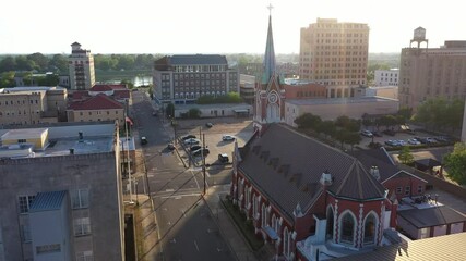 Wall Mural - Monroe, Louisiana, USA - April 4, 2024: Afternoon sunlight shines on the historic buildings and church in the skyline of downtown Monroe.