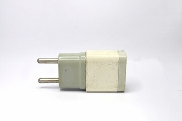 A close-up of a white, slightly dirty electrical wall charger with two metal prongs. The charger is isolated against a white background.