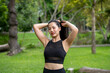 © apichat - A woman in a black tank top is posing in a park