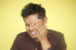 © Towfiqu Barbhuiya  - A Frustrated Man is Holding His Face in Discomfort Against a Bright Yellow Background