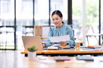 Business financing accounting banking concept. Business woman hand doing finances and calculate on desk about cost at home office. Woman working on desk with using calculator, finance accounting.
