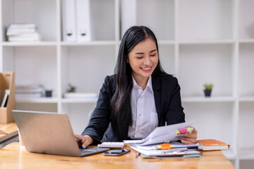 Wall Mural - Business asian woman Reviewing Documents, business woman's hands meticulously reviewing a stack of documents, highlighting the details and precision of her work. 
