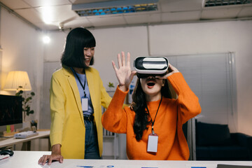 Two businesswomen having fun with virtual reality in a modern office, amazed and smiling, showcasing the future of digital work environments