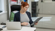© Михаил Решетников - Pregnant woman reading documents on a paper tablet in the office.