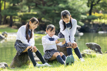 Wall Mural - 公園でスマホを見る女子学生