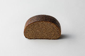 Sliced Dark Rye Bread Loaf Showing Textured Crumb on white background