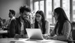 © Berkcan - Laughing young Indian executives corporate workers teammates of diverse gender use computer app together enjoy conversation discuss funny work situation. Two colleagues friends having fun on workplace