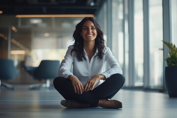 A happy woman sits on the floor with a warm smile