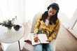 © peopleimages.com - Woman, home and wiring on diary with headphones for music, audio or podcast on chair. Female person, above and journaling for therapy or mindfulness in living room for motivation or inspiration