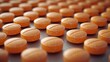 © Рудой Максим - An array of orange pills arranged uniformly on a textured surface in a clinical setting highlighting pharmaceutical production