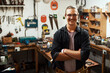© peopleimages.com - Happy man, portrait and carpenter with confidence for timber, woodwork skill or talent in garage workshop. Young, male person or professional artisan with smile or arms crossed in carpentry business