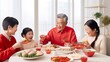 © Human AI - asian family in traditional red dress celebrating Chinese New Year enjoying food at home Chinese new year in white minimal living room interior