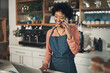 © peopleimages.com - Laptop, phone call and entrepreneur with woman in cafe for supplier invoice, store inventory and planning. Communication, barista and franchise admin with person in coffee shop for restaurant stock