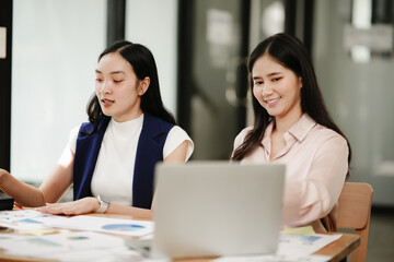 Asian Businesswoman sitting and doing paperwork, office