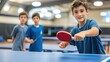 © Ariestia - Young boy playing table tennis with a focused expression