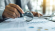 © Denis Yevtekhov - Auditor Reviewing Financial Statements with Magnifying Glass